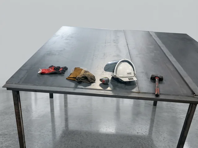 Fabrication Worktable — A metal worktable with tools and fabrication work in progress.